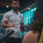 Sesión de entrenamiento en el gimnasio con un entrenador personal, enfocada en el rendimiento y el bienestar físico.